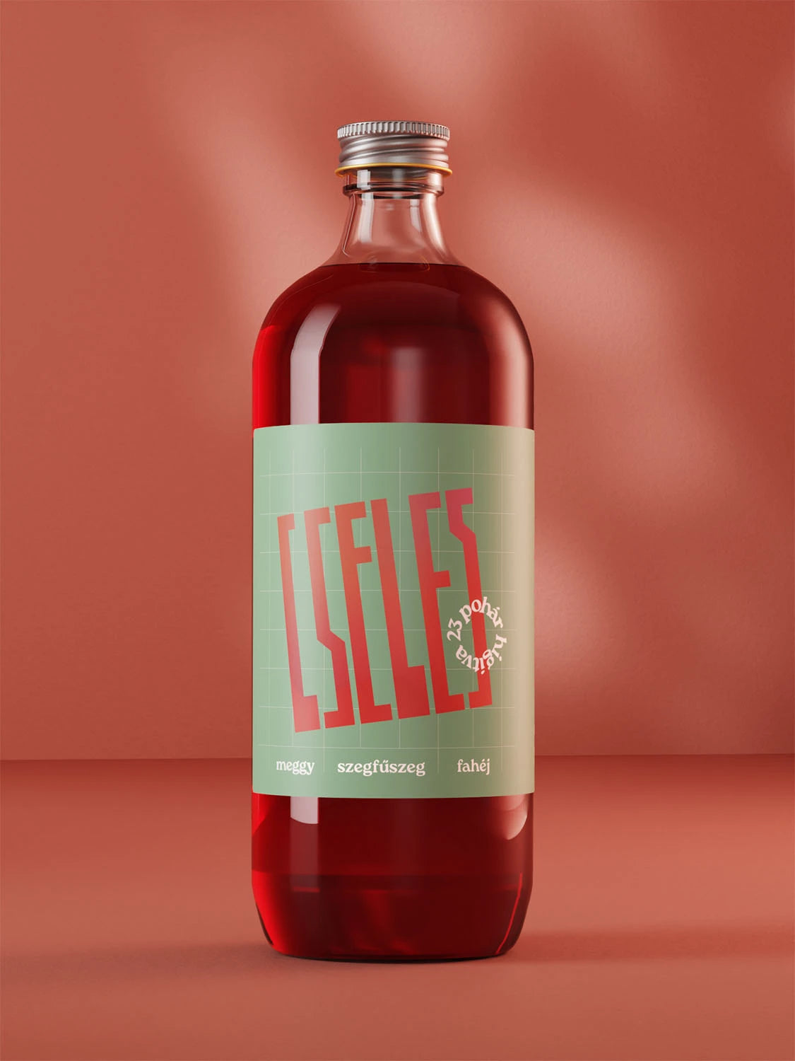 Egy üveg Cseles alkoholos ital áll élénk piros háttérrel. Ízében meggylé, fahéj és szegfűszeg is felfedezhető.